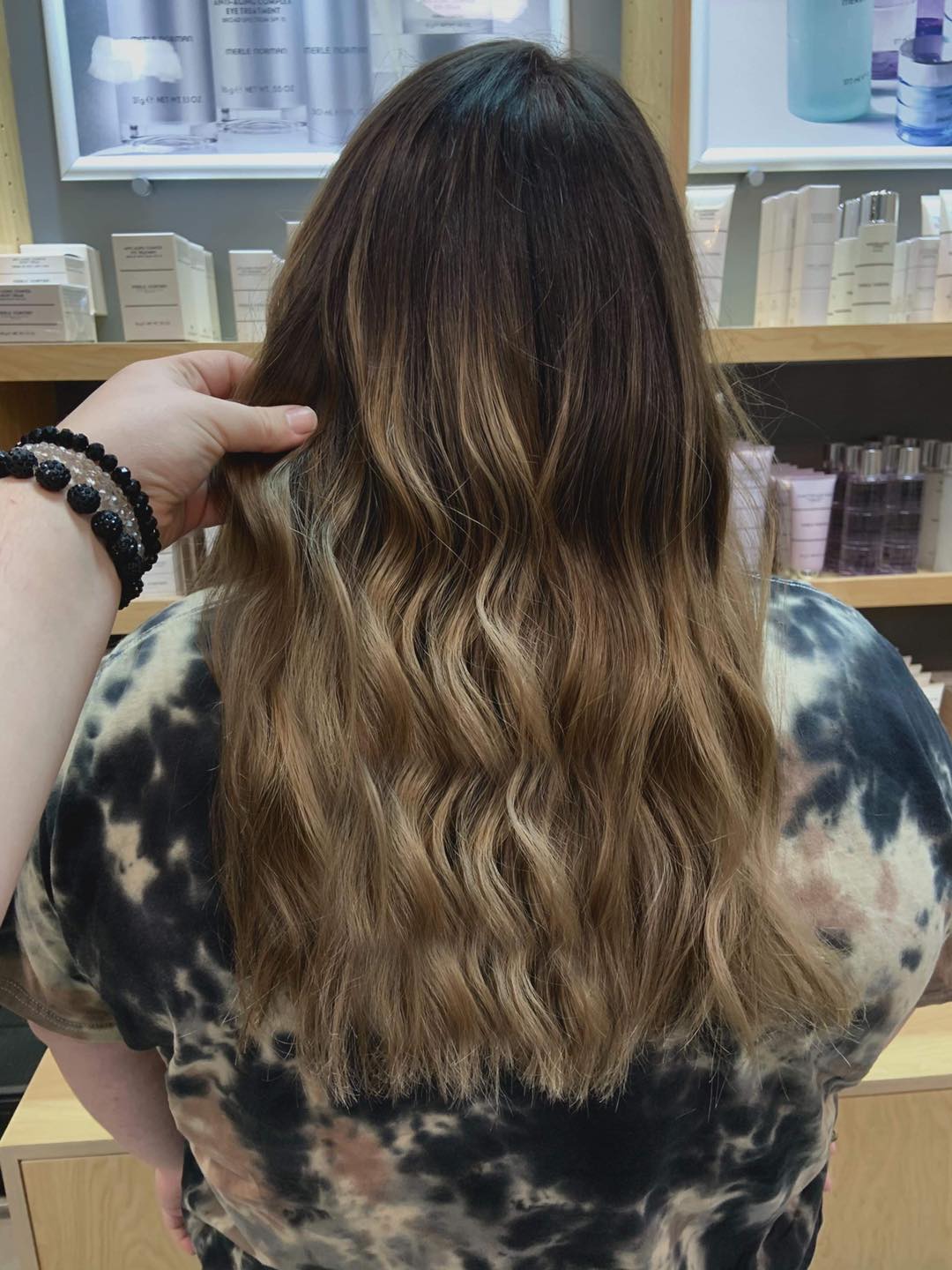A person is touching a woman 's hair in a store.