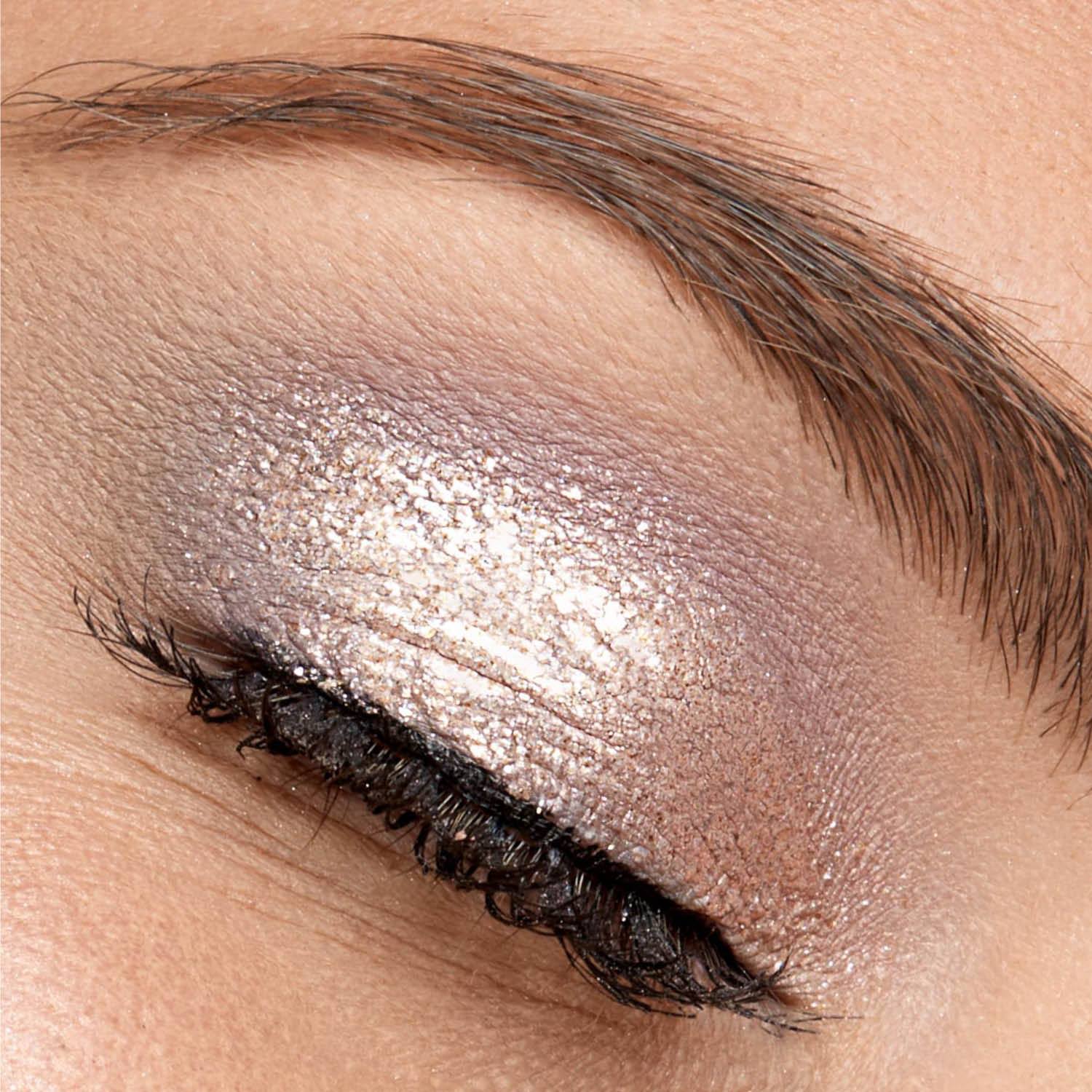 A close up of a woman 's eye with silver eye shadow
