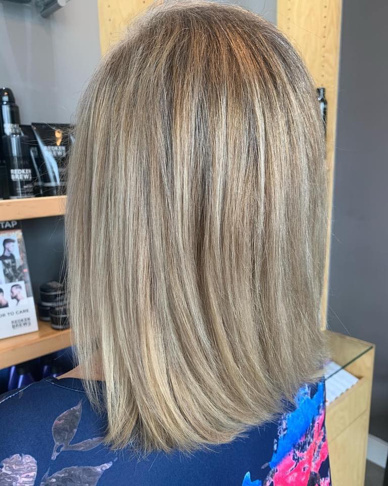 The back of a woman 's hair is shown in a salon.