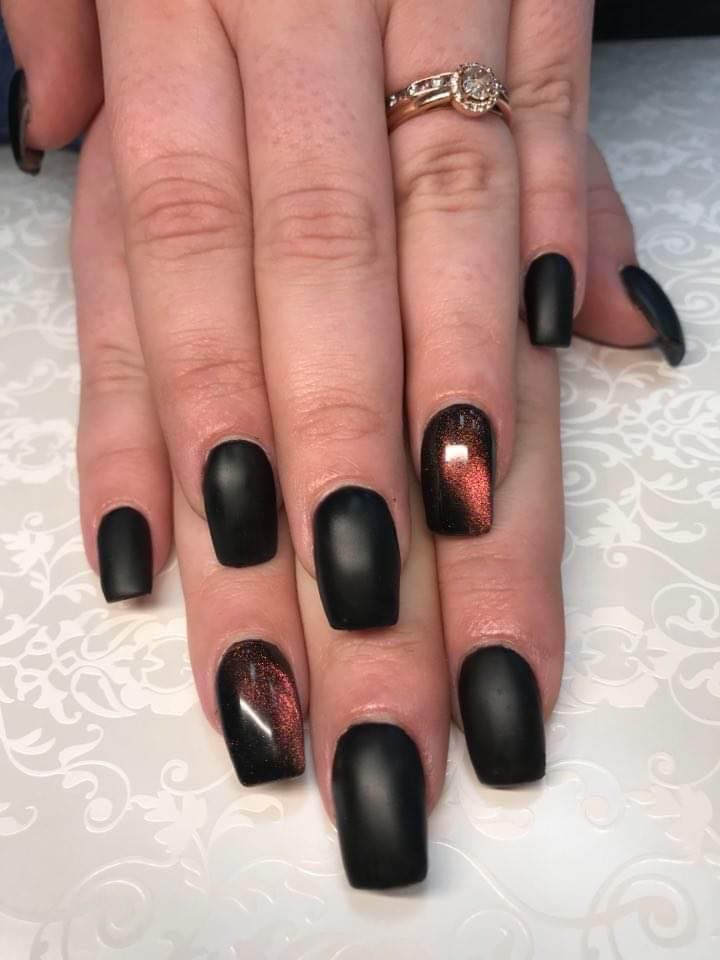 A close up of a woman 's nails with a ring on her finger.