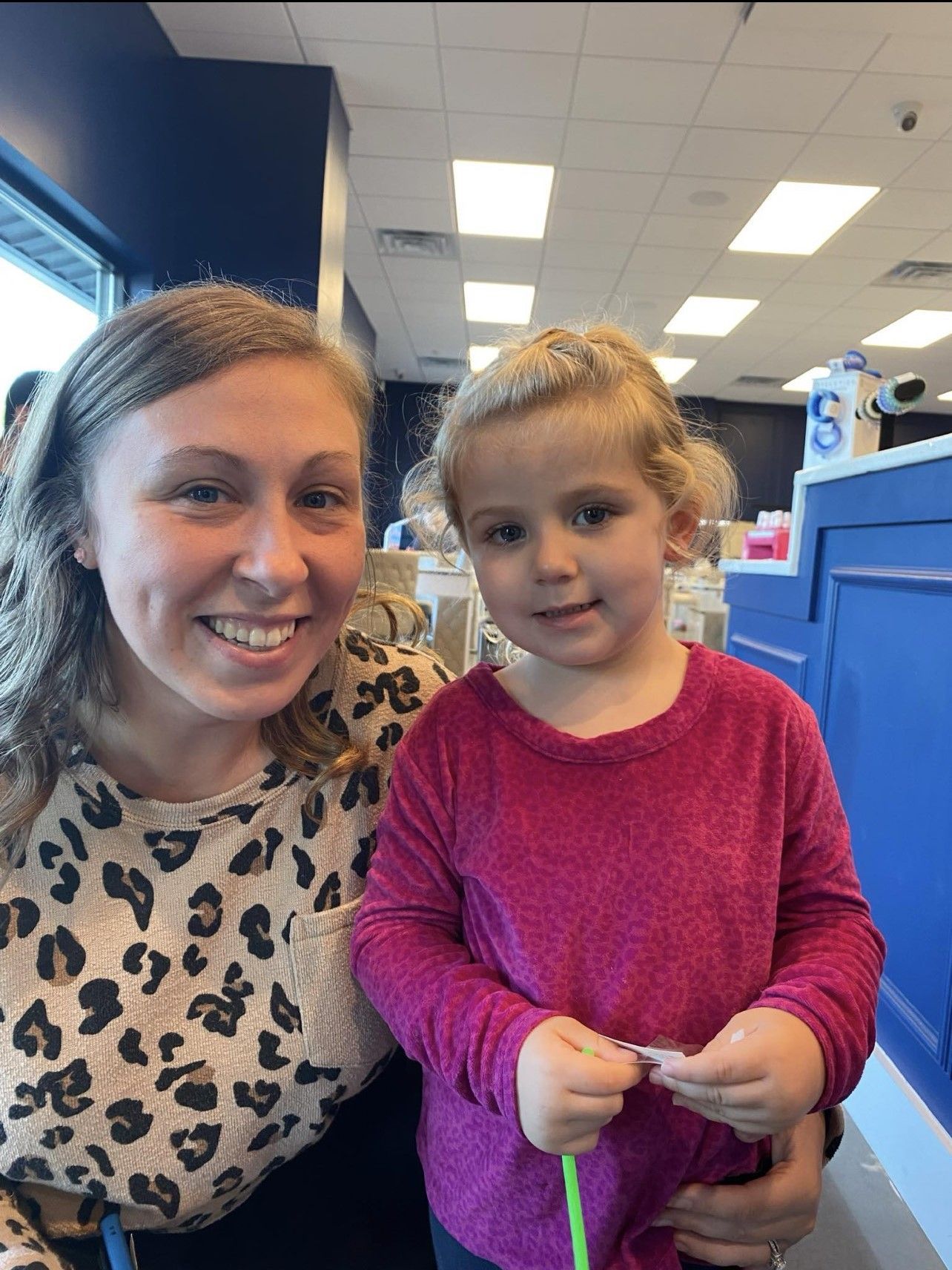 A woman and a little girl are posing for a picture in a restaurant.