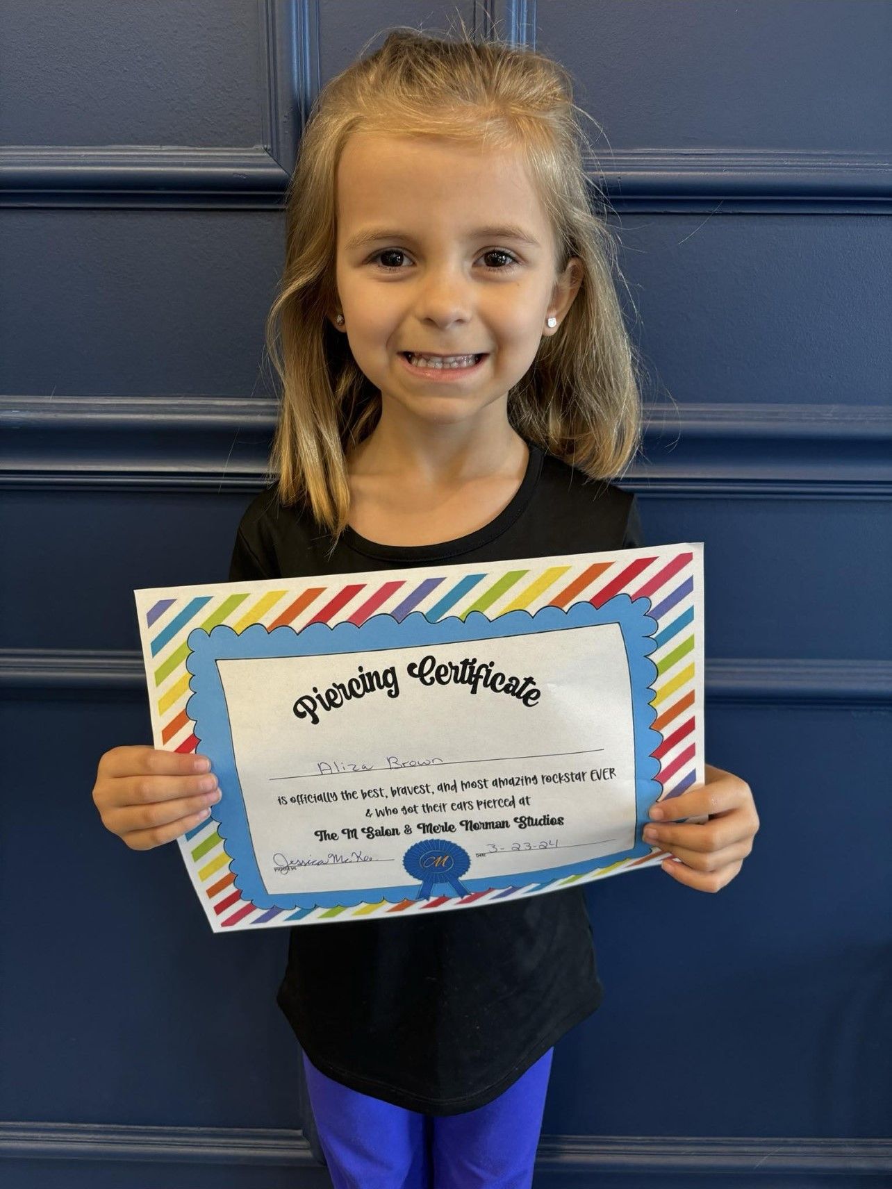 A little girl is holding a certificate in her hands