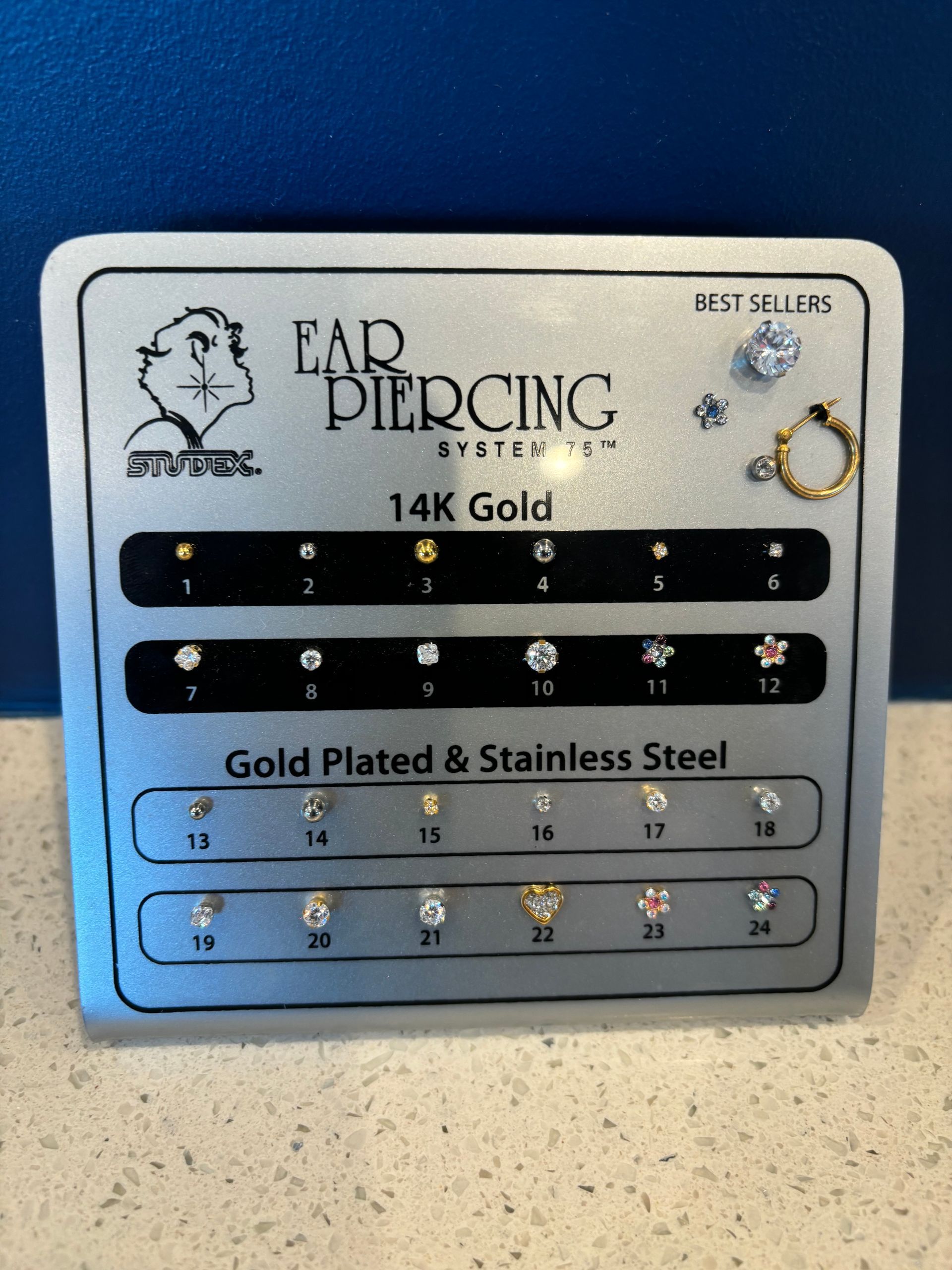 A box of 14k gold ear piercing jewelry