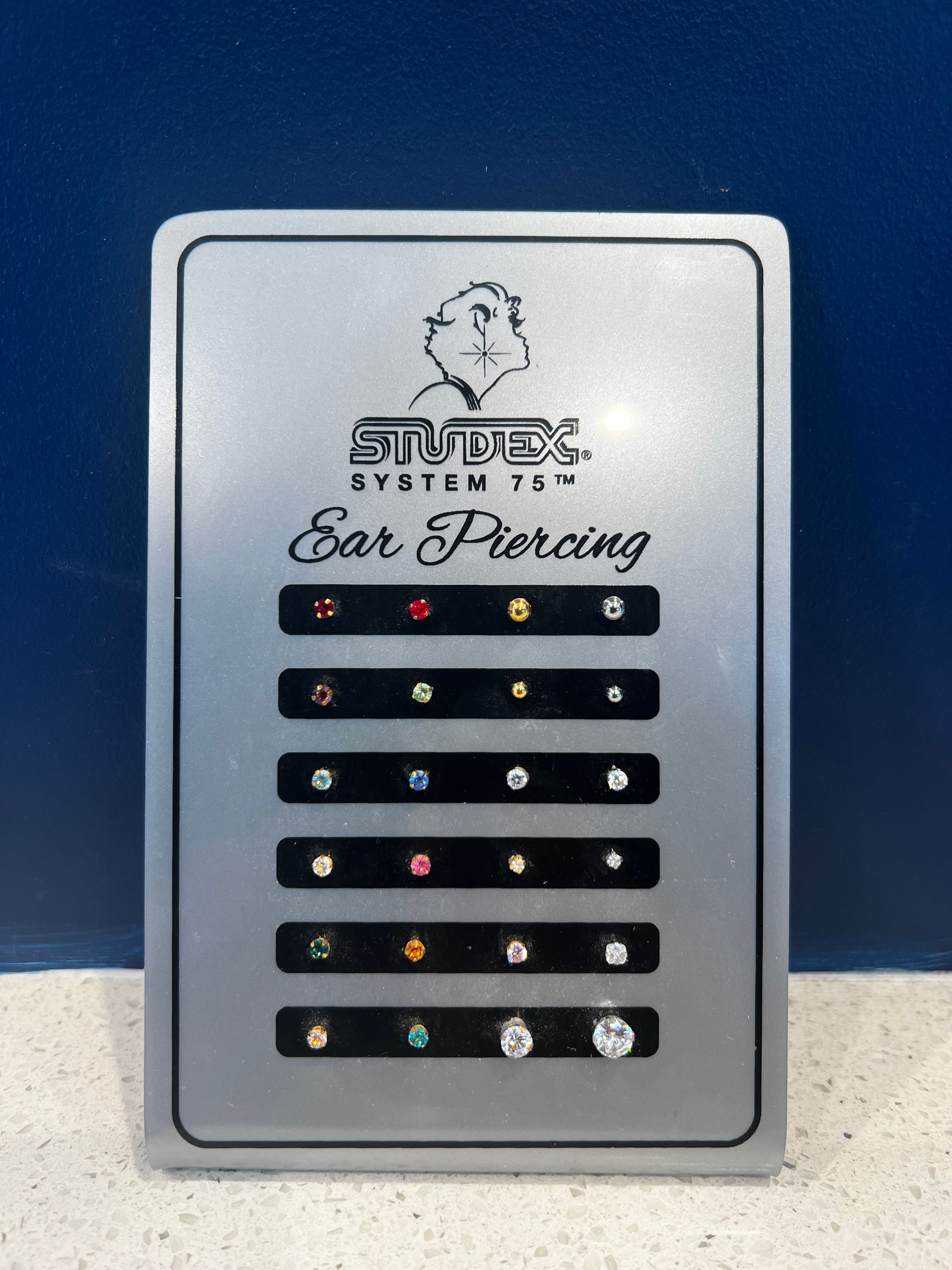 A display of ear piercings with a blue background