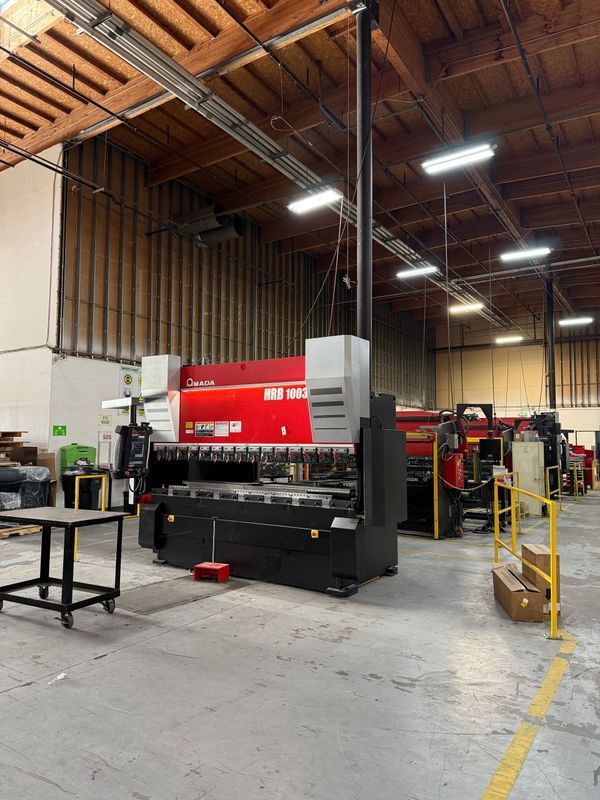 Industrial factory interior with red and black sheet metal press.