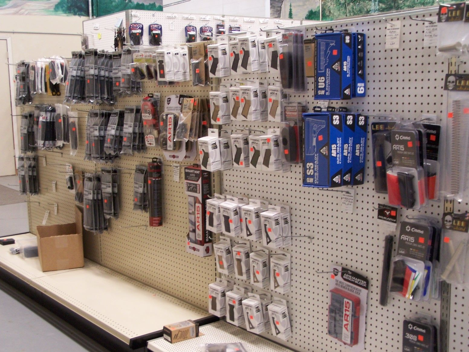 A retail display of electronic accessories packaged on a pegboard wall.