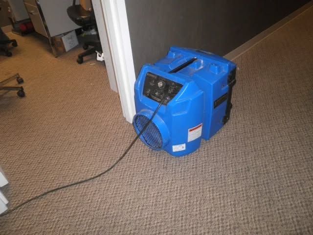 An overhead view of turquoise ocean waves crashing and forming white foam against deep blue water.