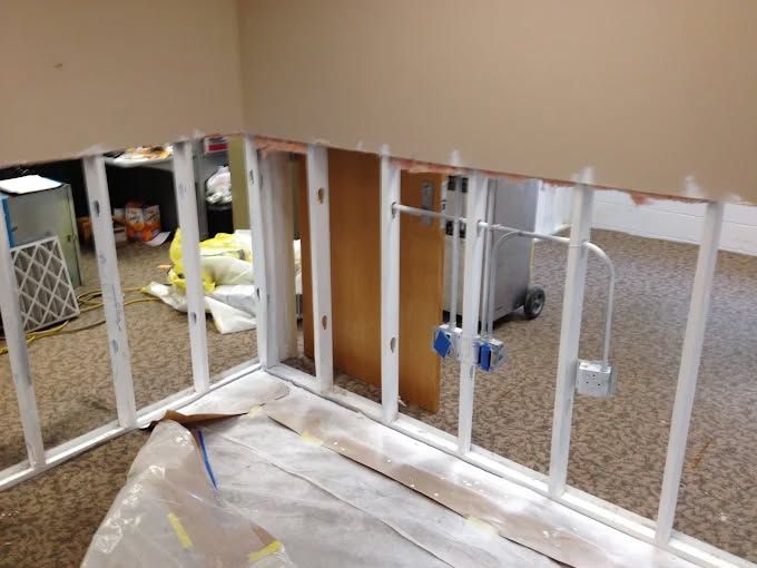 An aerial view of a dark blue river winding through a dense, lush green forest.