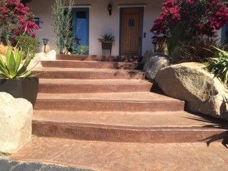 A set of stairs leading up to a house with flowers in the background.