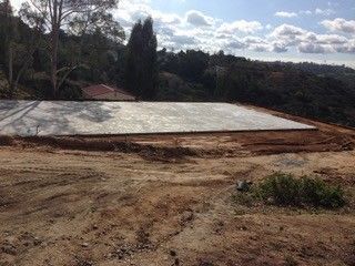 A large concrete slab is sitting on top of a dirt hill.