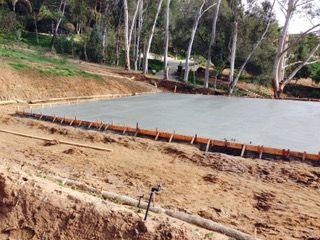 A large concrete slab is sitting on top of a dirt hill.