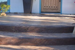 A set of stairs leading up to a house with a wooden door.