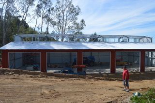 A man is standing in front of a large building under construction.