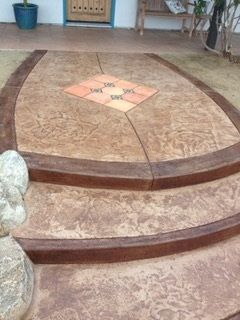 A concrete patio with steps and a statue in front of it.