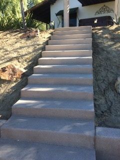 A set of concrete stairs leading up to a house.