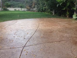 A concrete driveway with a grassy area in the background.