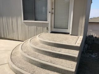 A set of curved concrete steps leading up to a house.