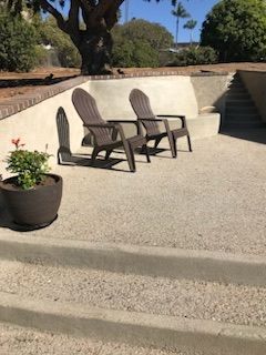 Two chairs are sitting on a patio next to a bench.