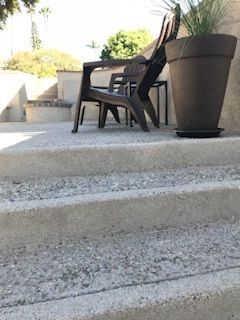 A couple of chairs sitting on top of a set of stairs next to a potted plant.