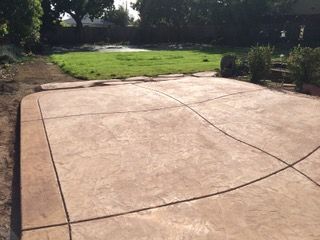 A concrete driveway with a grassy field in the background.