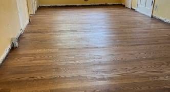 A long hallway with a wooden floor in a house