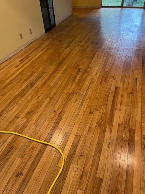 A living room with hardwood floors and a yellow cord