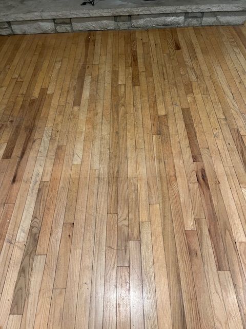 A wooden floor with a fireplace in the background
