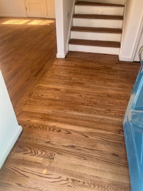 A wooden floor with stairs in the background in a house
