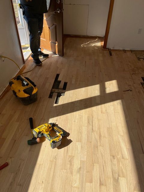 A man is standing in a room with tools on the floor