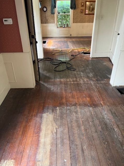 A wooden floor in a room with a door and a window
