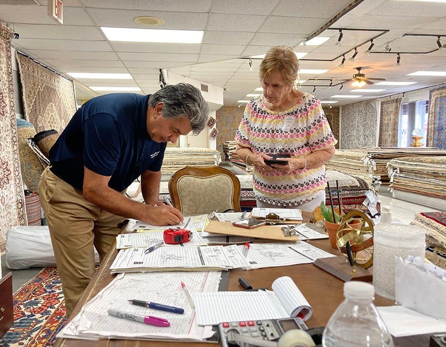 A man and a woman are working at a table in a store.