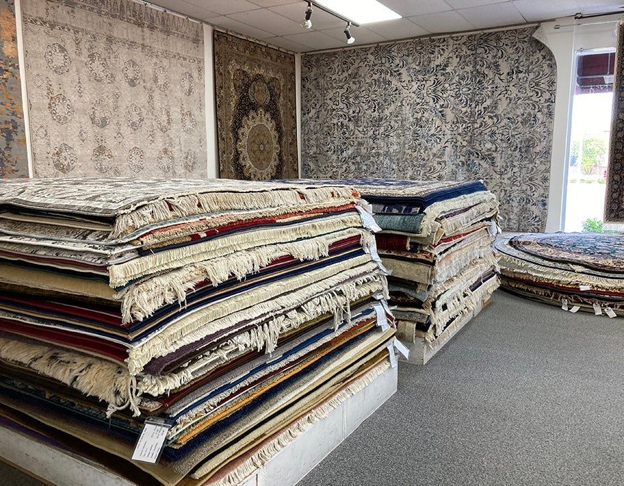 A room filled with lots of rugs stacked on top of each other.