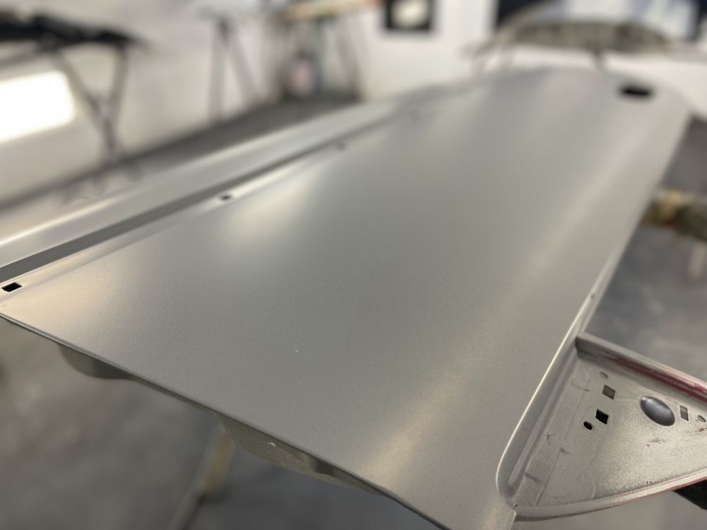 Gray metal panel on a workshop stand, viewed close up in a factory setting