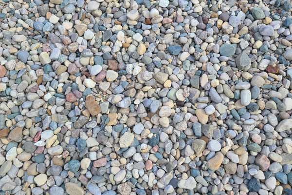 A pile of rocks of different sizes and colors on a beach.