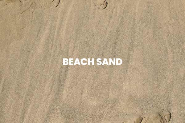 A pile of sand with the words beach sand written on it.