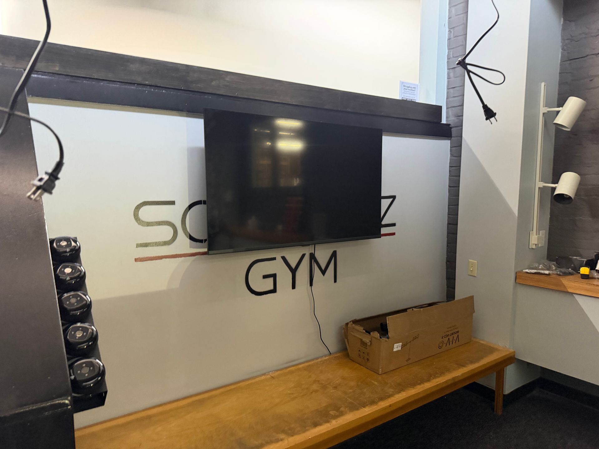 A flat-screen TV mounted on a wall featuring the logo 