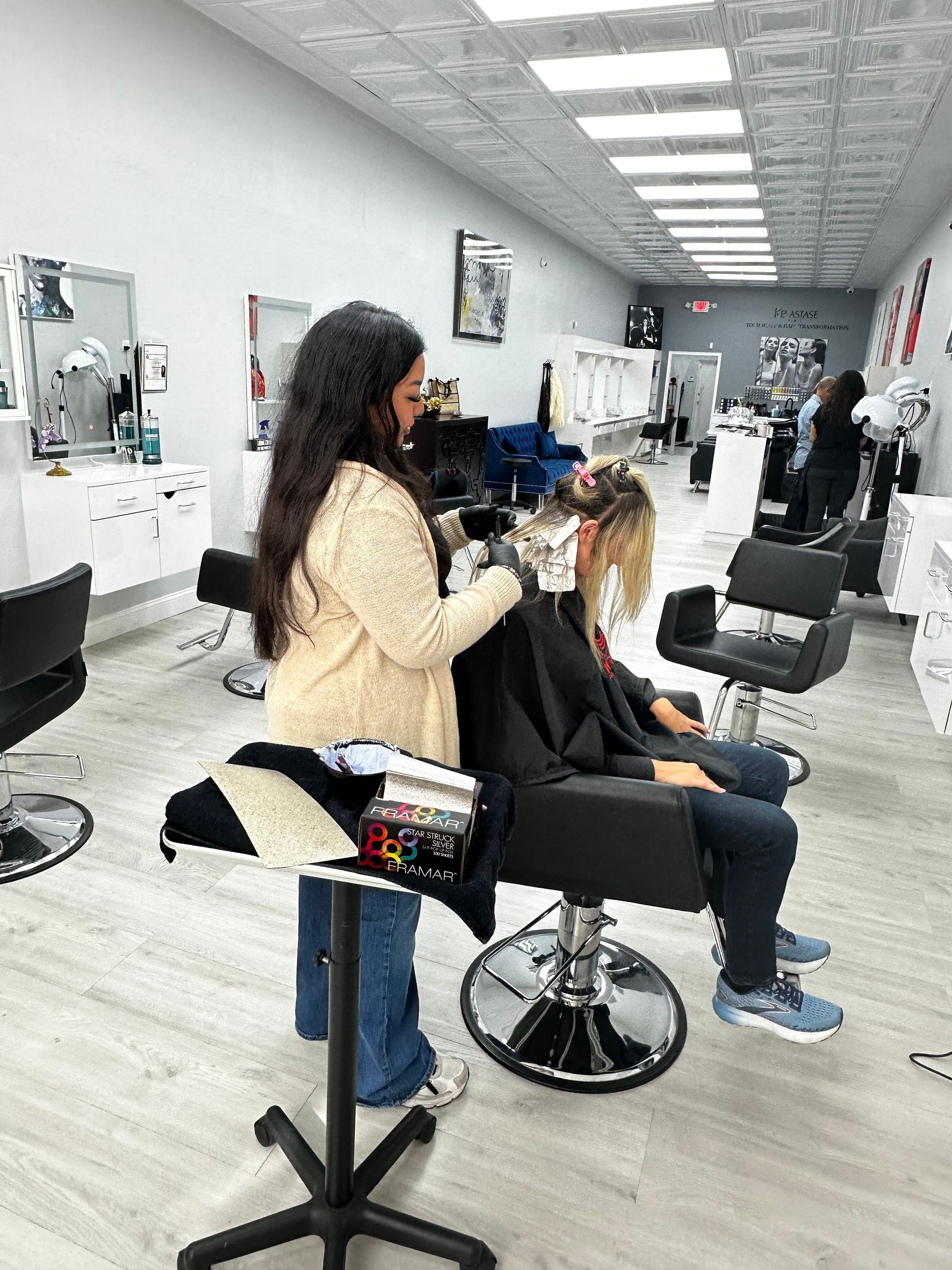 A woman is cutting a woman 's hair in a salon.