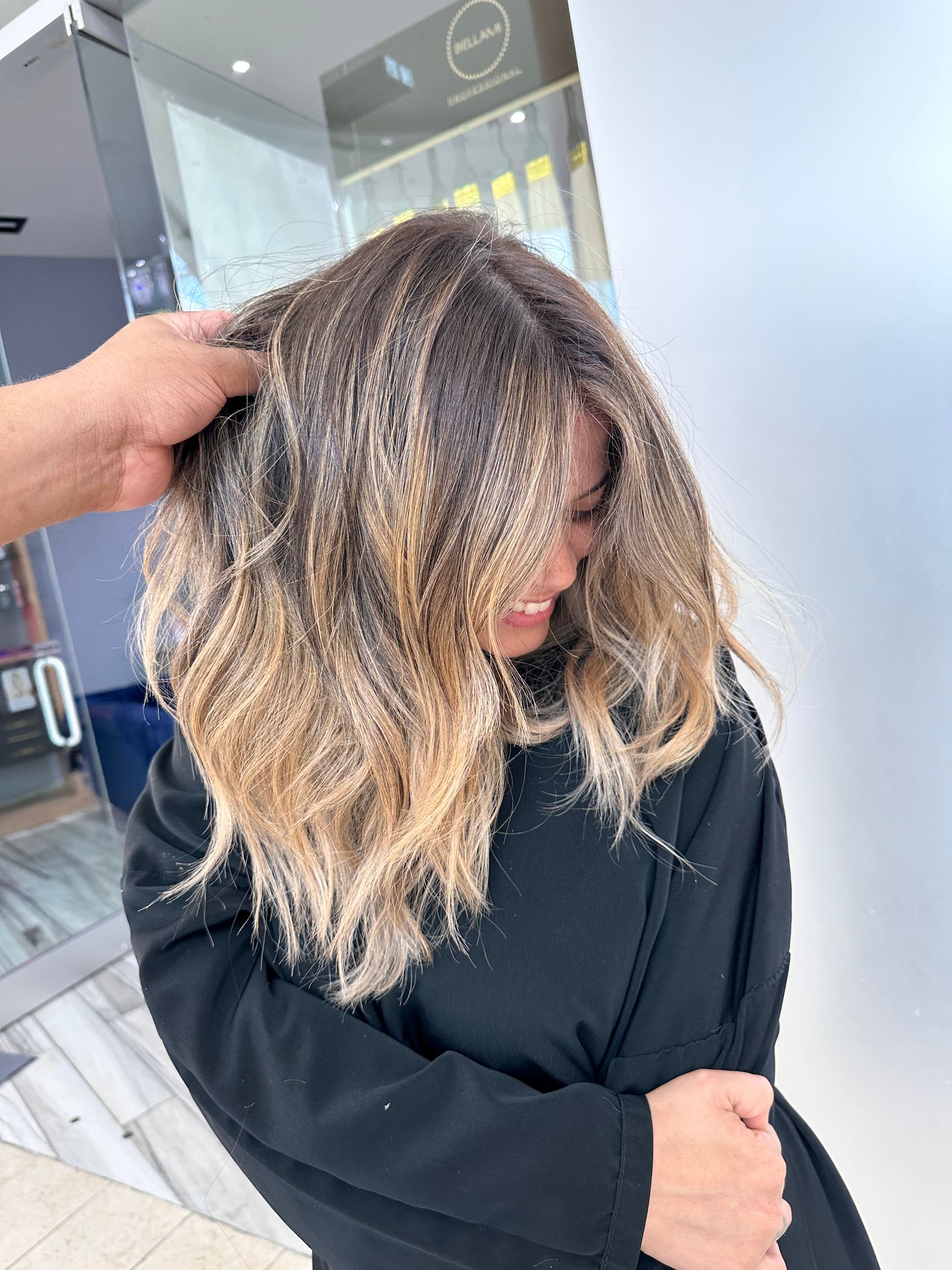 A woman is getting her hair done by a hairdresser in a salon.