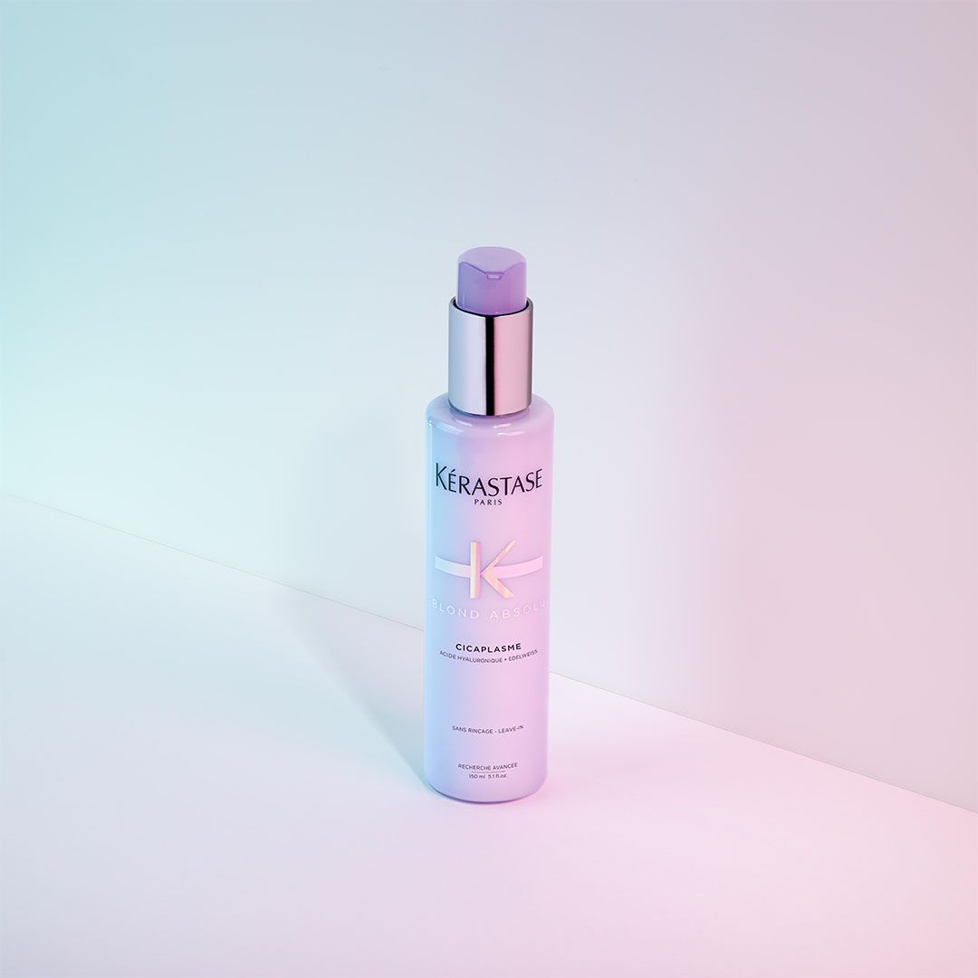 A bottle of Kérastase hair product is sitting on a table
