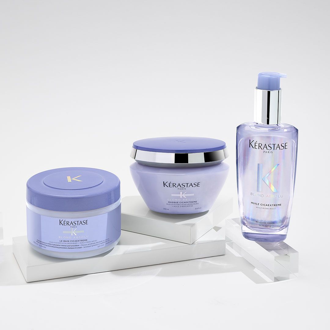 A bottle of shampoo, a jar of cream, and a bottle of lotion are on a table