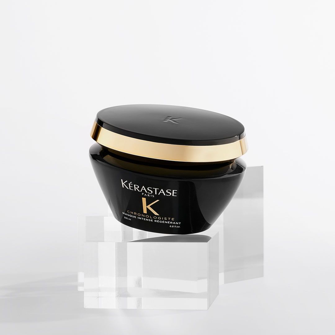 A jar of Kérastase K is sitting on top of a clear cube