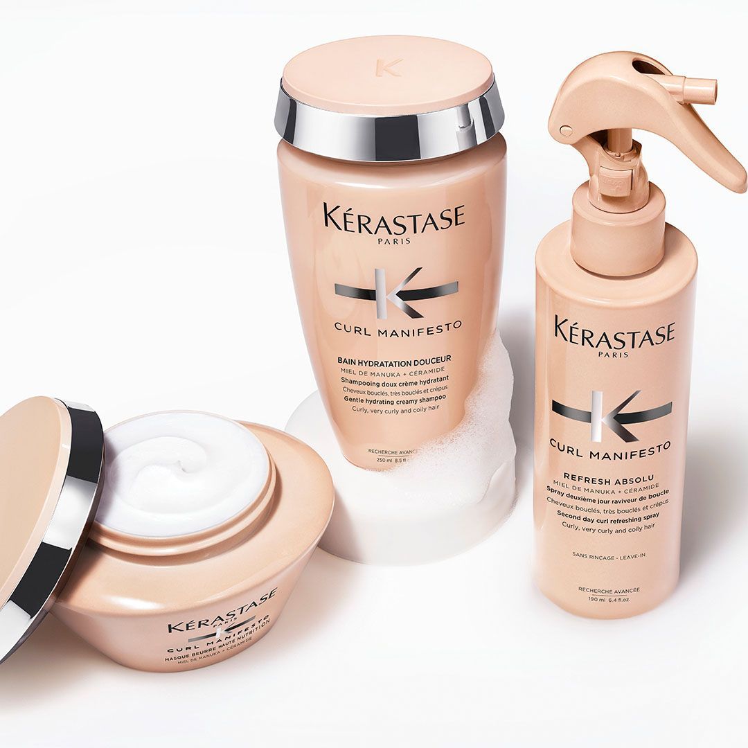 Three bottles of Kérastase hair products are sitting on a white surface