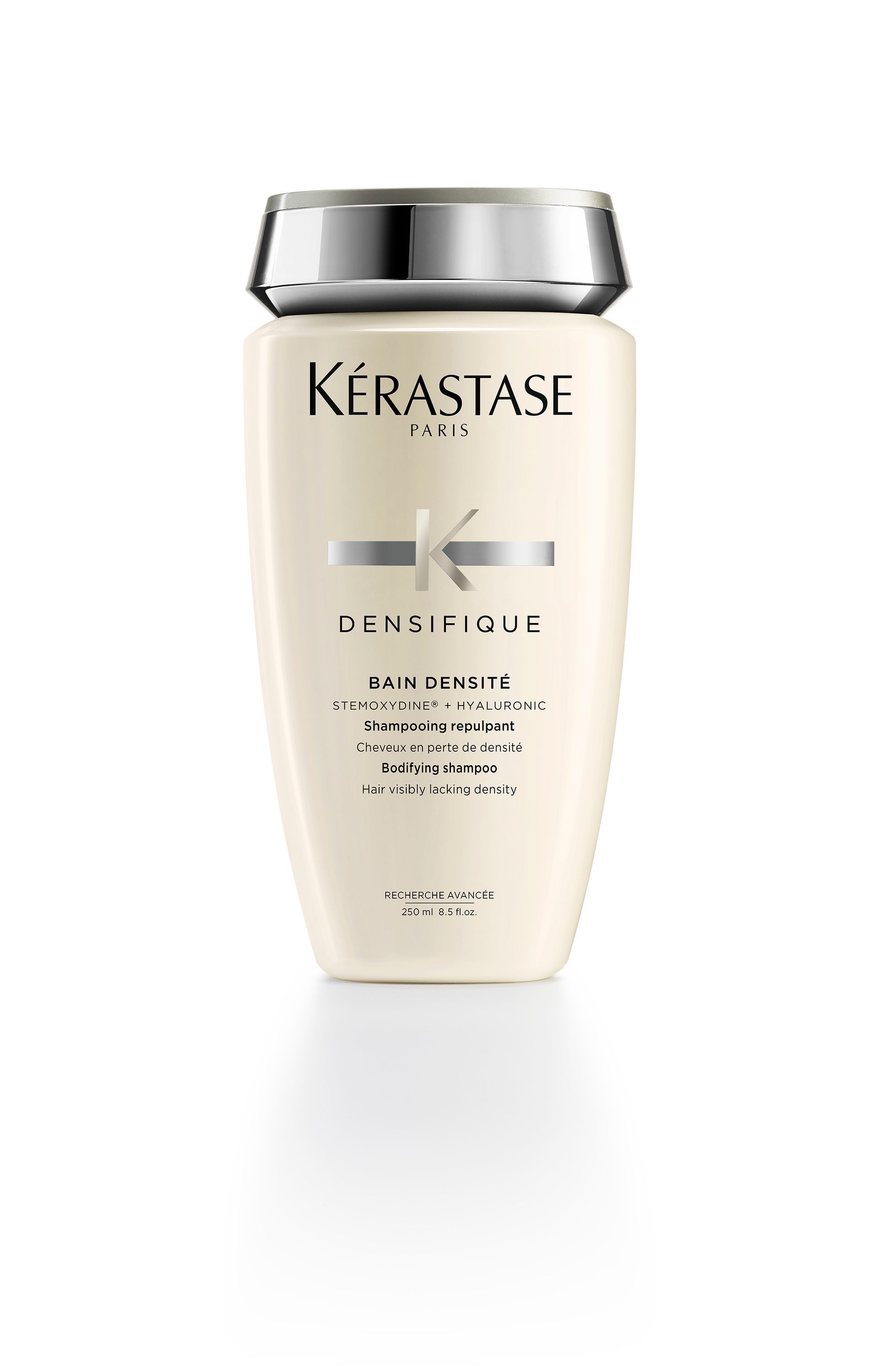 A bottle of Kérastase Densifique shampoo on a white background