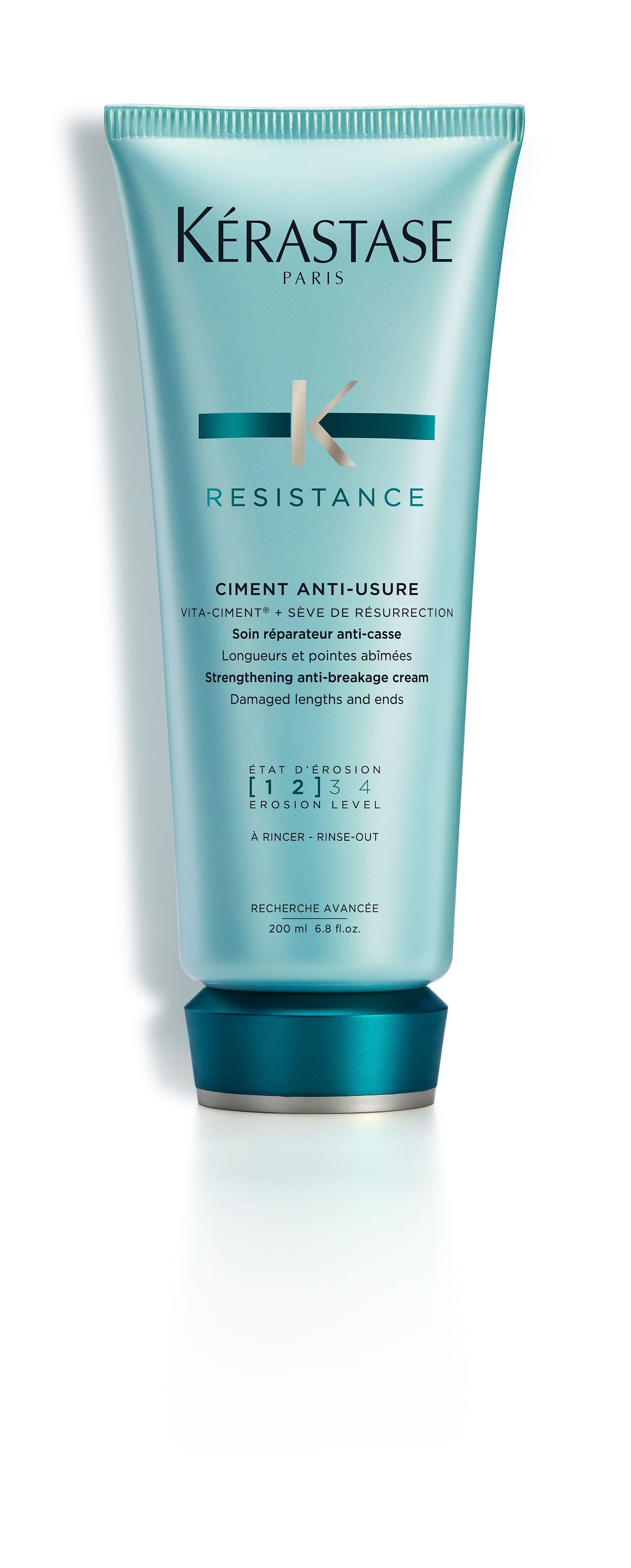A bottle of Kérastase resistance conditioner on a white surface.