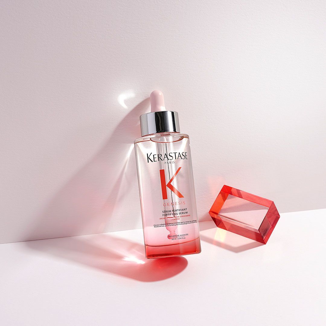 A bottle of Kérastase hair serum is sitting on a table