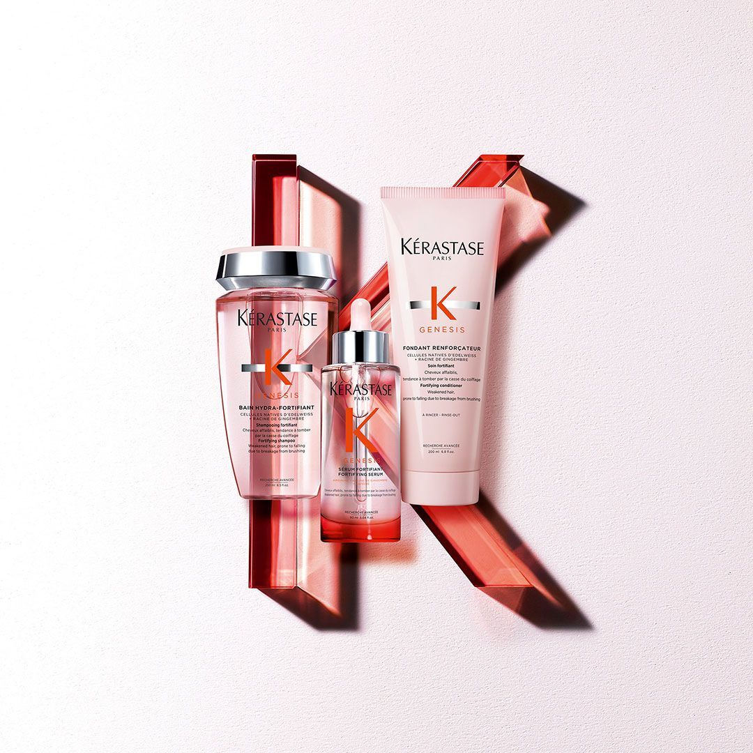 Three bottles of Kérastase hair products are sitting on a white surface.
