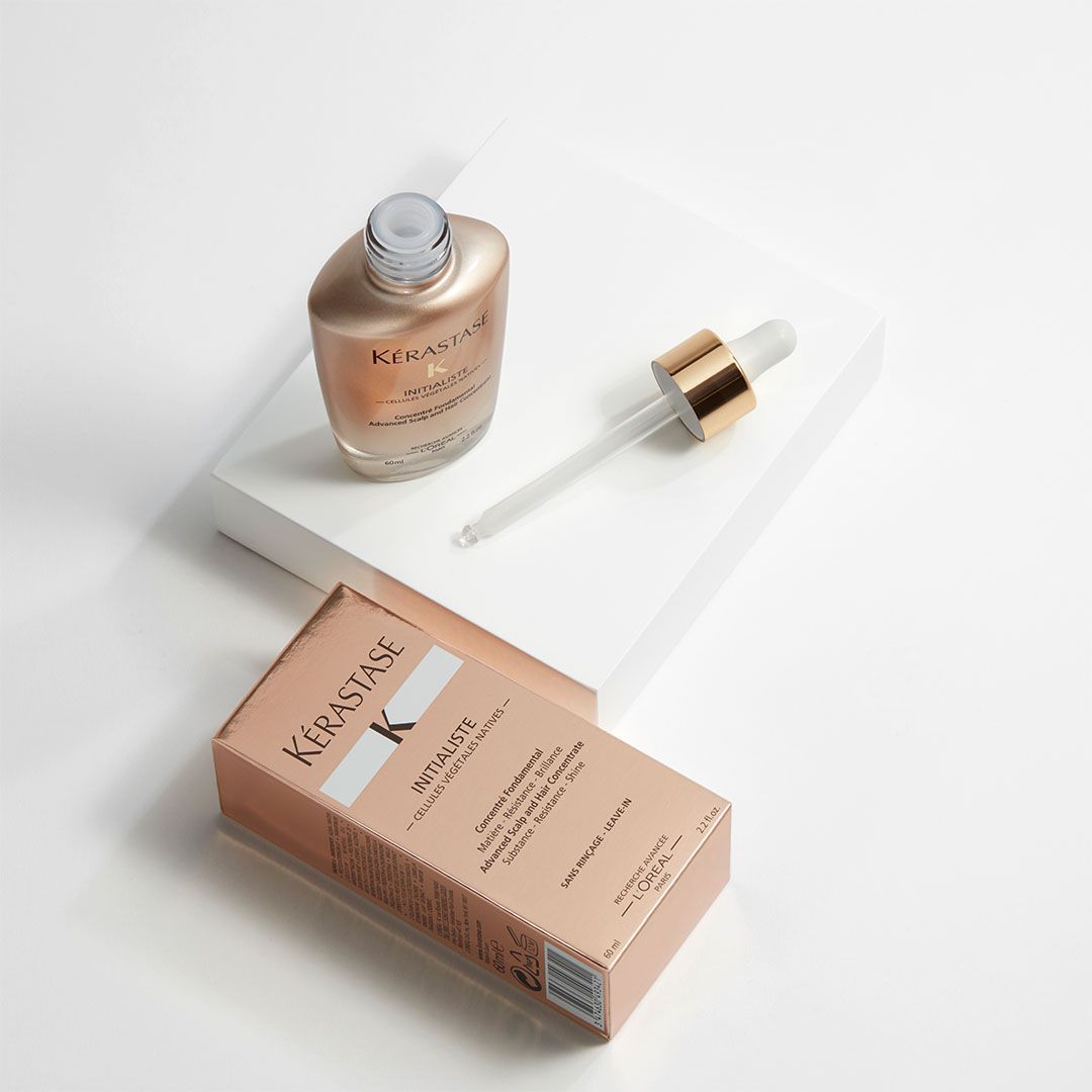 A bottle of Kérastase serum next to a box