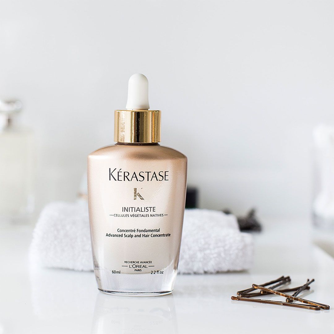 A bottle of Kérastase hair serum is sitting on a table