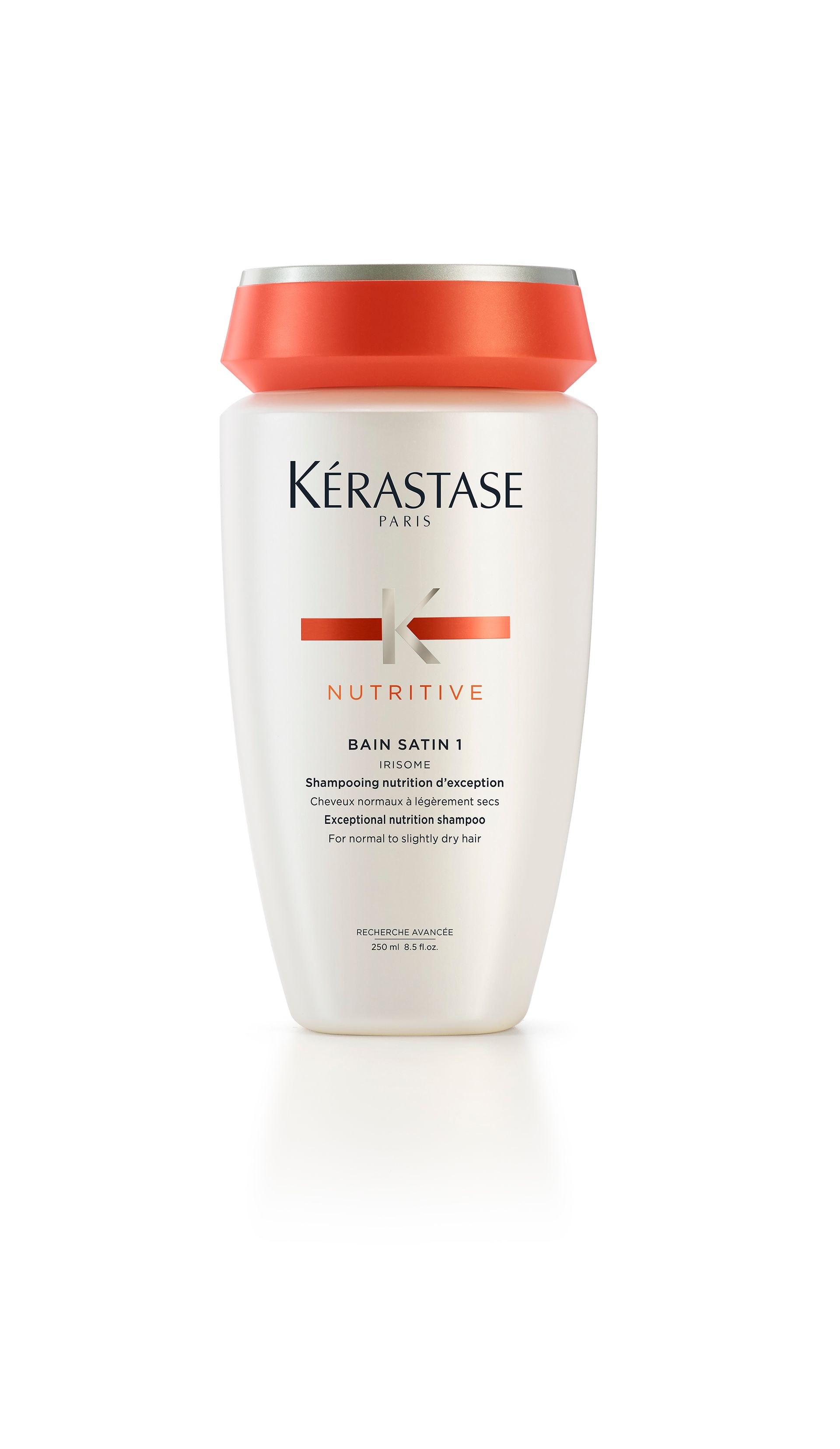 A bottle of Kérastase shampoo on a white surface