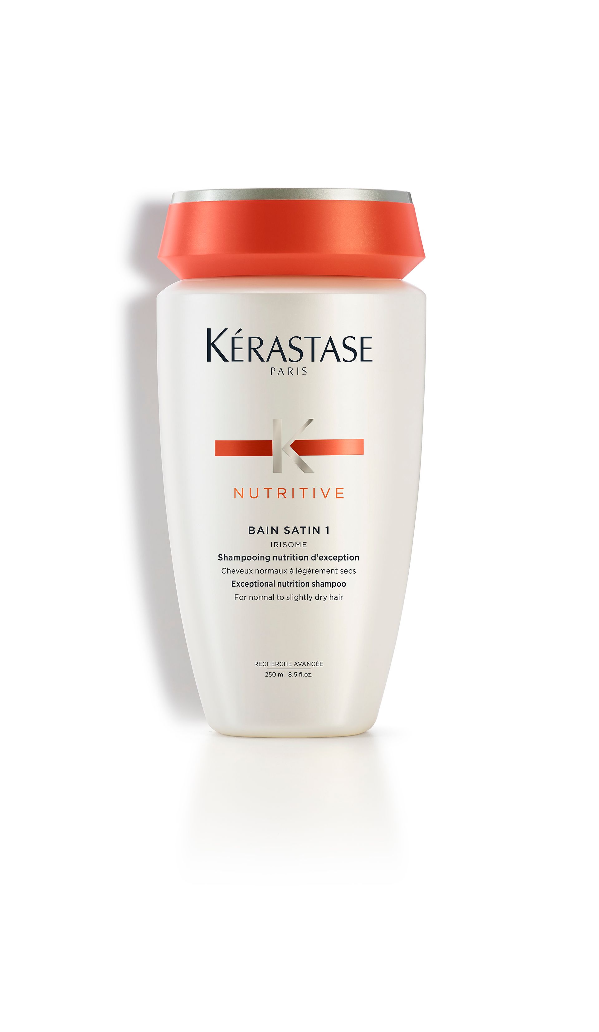 A bottle of Kérastase shampoo on a white surface
